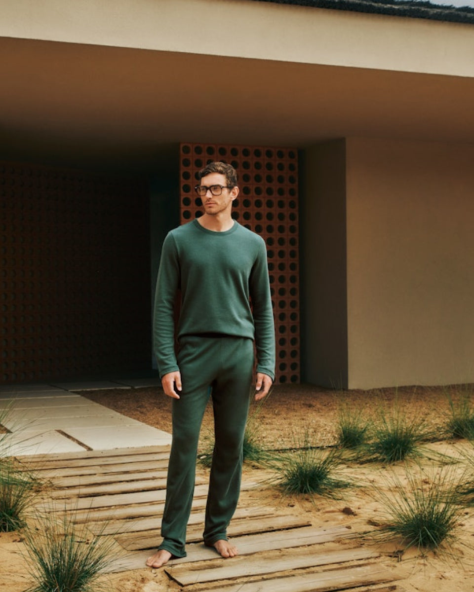 Man standing in front of a building wearing Smart Sleep Organic Cotton Pajama Set in Herbal Tea