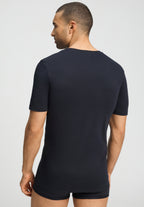 Man wearing a black t-shirt and underwear on a light gray background