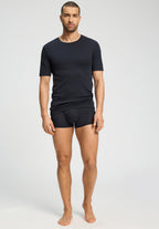 Man wearing a black t-shirt and black underwear on a white background