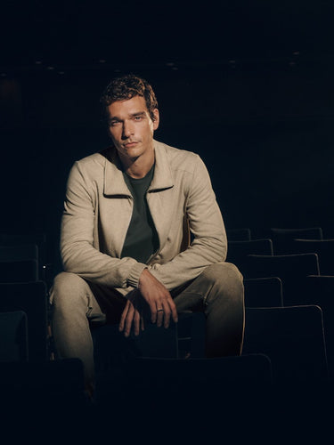 Man sitting alone in a dark theater with a spotlight on him