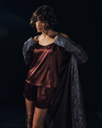 Woman wearing Grand Central Silk Camisole and Knickers in vivid brown with men's Selection robe