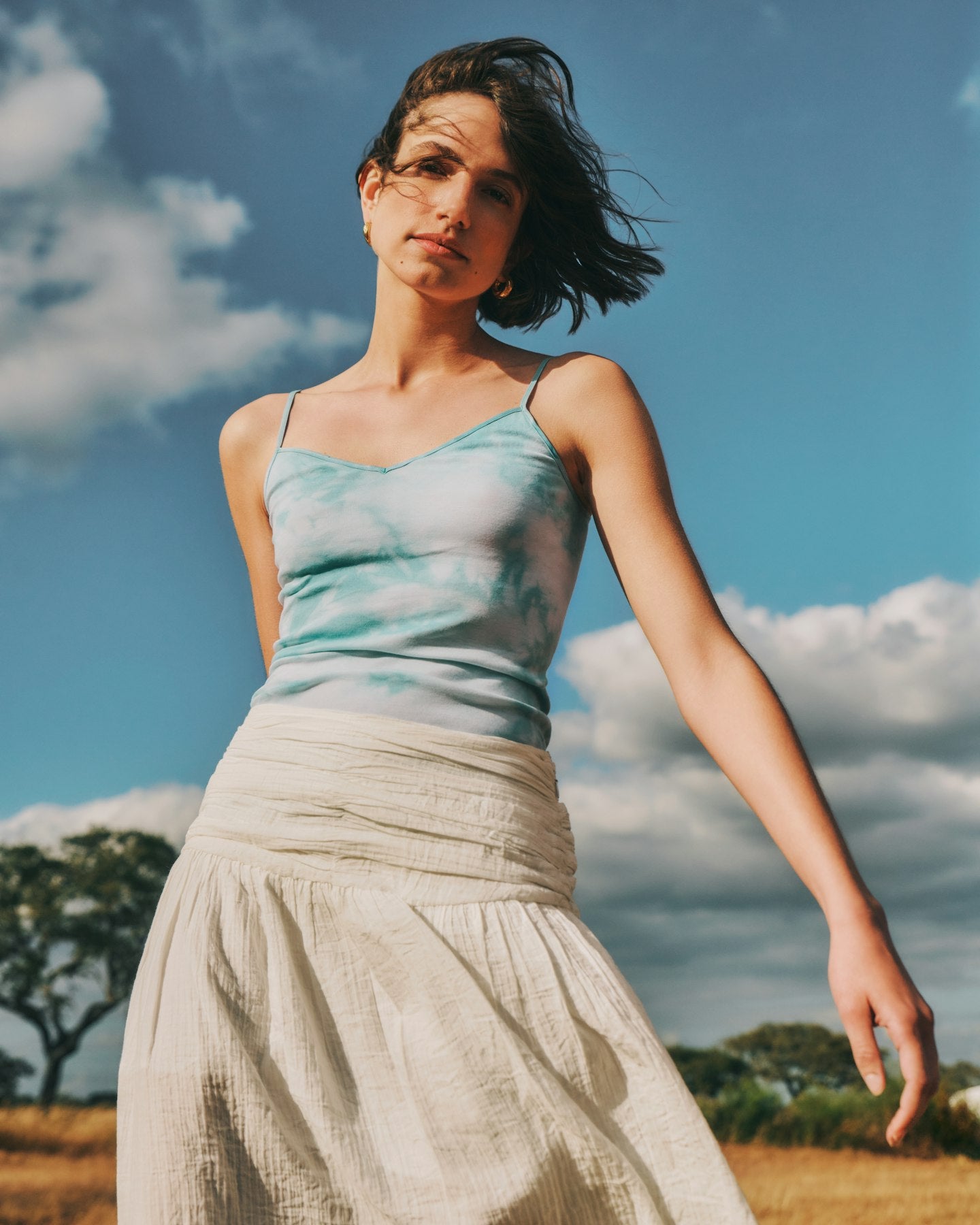Woman wearing a tie-dye Cotton Seamless Camisole, paired with a flowing skirt.