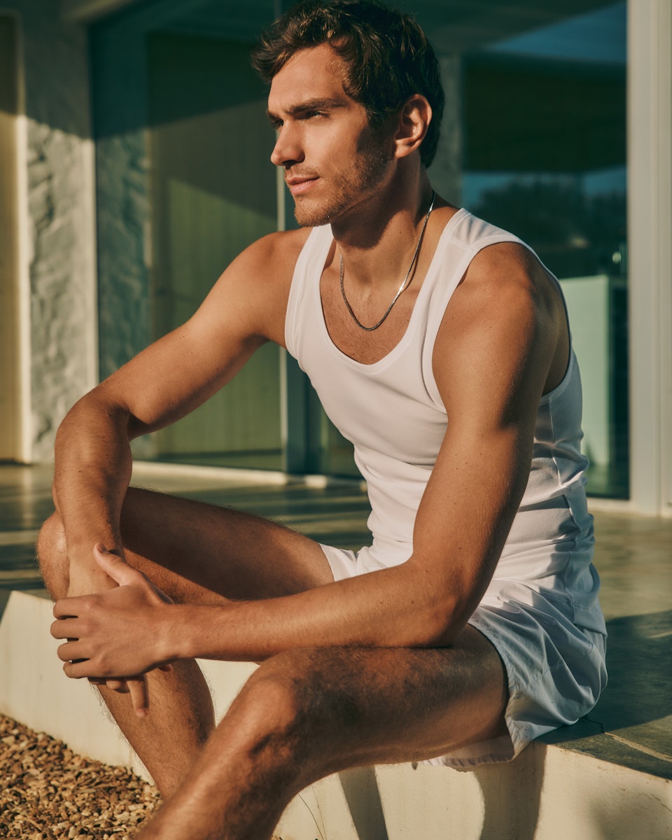 Man sitting outside wearing Cotton Essentials Tank Top paired with Fancy Woven Boxers.