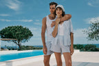Couple standing by a pool with a scenic background