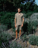 Man standing in a lavender field wearing a brown outfit.