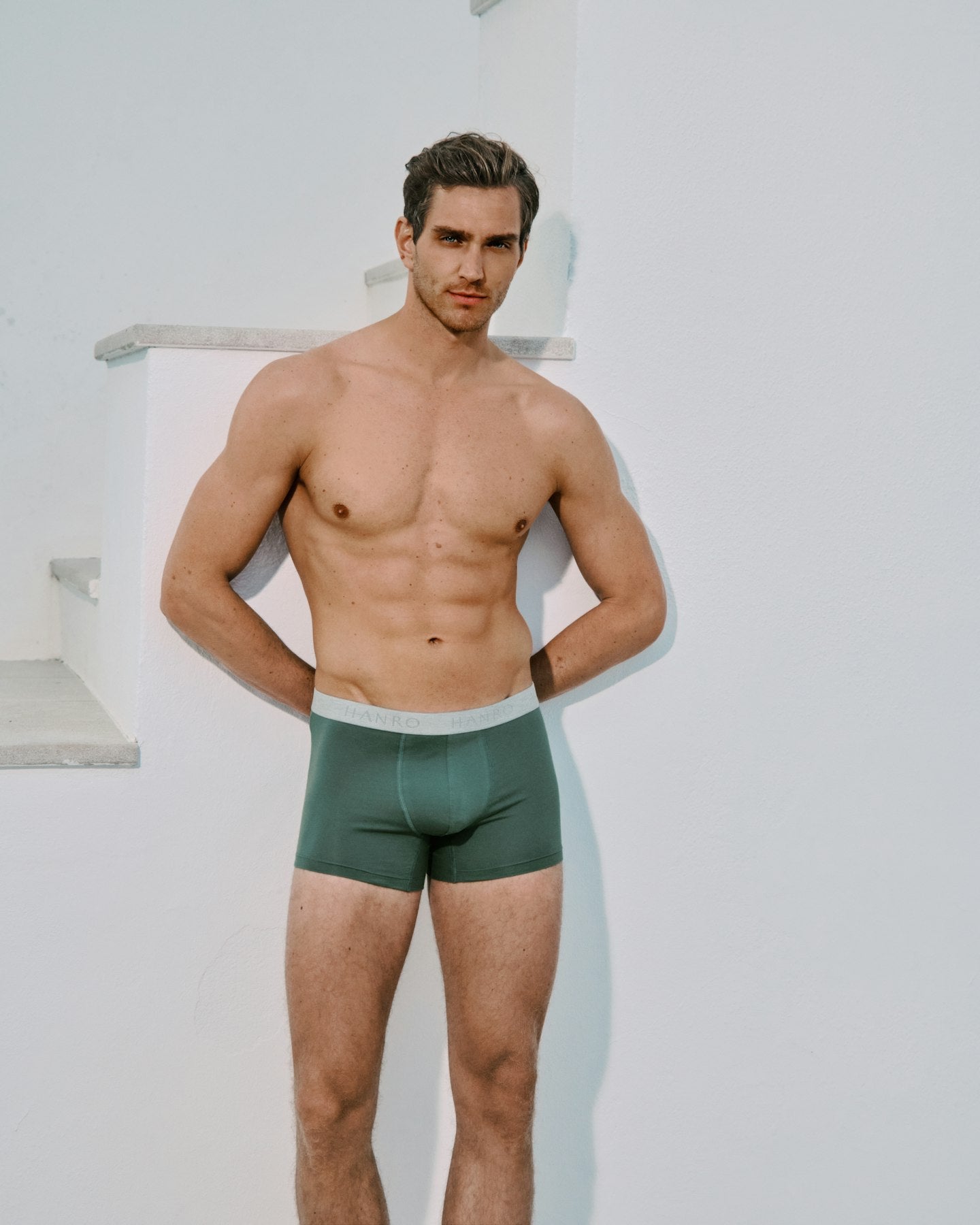 Man wearing green Cotton Essentials underwear against a white background