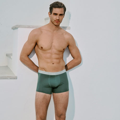 Man wearing green Cotton Essentials underwear against a white background