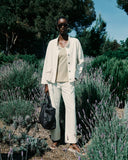 Person in a white outfit standing among lavender plants