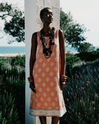 Woman in a patterned dress standing in a field with lavender and ocean view