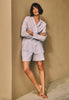 Women leaning against wall with arms crossed wearing Sleep And Lounge Cotton Button Front Pajama Shirt in Pastel Dream paired over sleep shorts. 