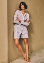 Women leaning against wall with arms crossed wearing Sleep And Lounge Cotton Button Front Pajama Shirt in Pastel Dream paired over sleep shorts. 